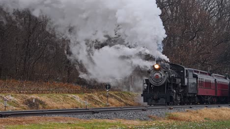 Una-Vista-De-Un-Antiguo-Tren-De-Pasajeros-De-Vapor-Restaurado-Que-Se-Acerca,-Soplando-Mucho-Humo-Y-Vapor-En-Un-Día-De-Invierno