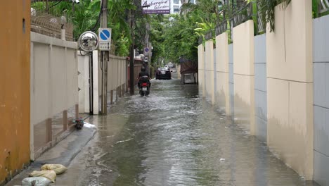 A-motorcyclist-rides-through-the-flooded-streets-of-Bangkok,-Thailand