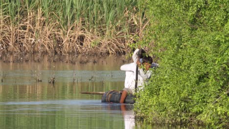 Toma-De-Lugareños-Pasando-Con-Una-Balsa-Improvisada-Después-De-Graves-Inundaciones-En-Sindh,-Pakistán-Durante-El-Día