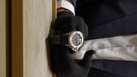 Toma-Vertical-De-Las-Manos-De-Un-Vendedor-Con-Guantes-Negros-Que-Muestra-Un-Costoso-Reloj-Panerai-Luminor-En-La-Boutique