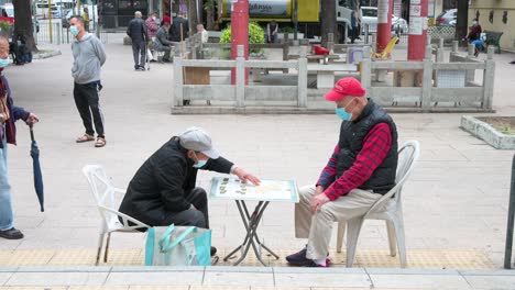 Senior-men-wearing-face-masks-play-chess-at-a-park-in-Hong-Kong