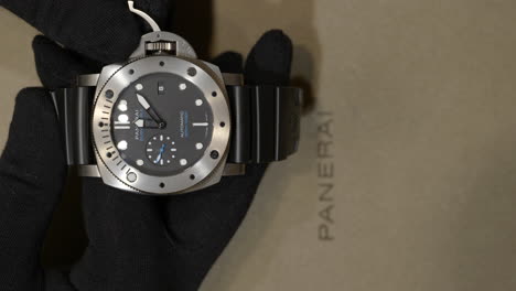 Comerciante-Con-Guantes-Ajustando-La-Hora-Del-Reloj-De-Pulsera-De-Lujo-En-La-Boutique-Panerai