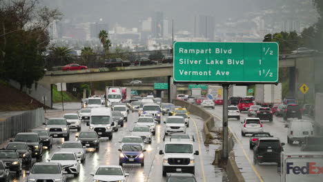 Mucho-Tráfico-Bajo-La-Lluvia-En-Los-ángeles-Con-Hollywood-En-El-Fondo,-Autopista-101