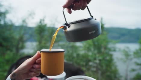 Hand-Gießt-Während-Der-Pause-Vom-Roadtrip-Heißen-Gebrühten-Kaffee-In-Die-Tasse-Im-Freien