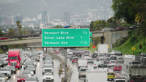 Una-Toma-Amplia-De-Tráfico-Pesado-Bajo-La-Lluvia-En-La-Autopista-101-En-Los-ángeles-Con-Una-Señal-De-Tráfico