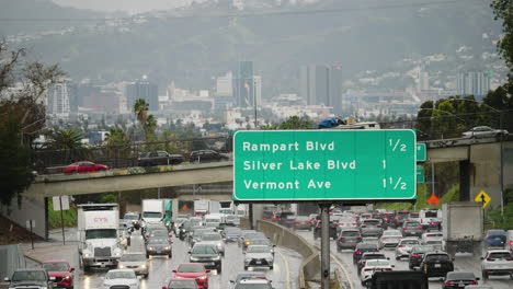 Una-Toma-Amplia-De-Tráfico-Pesado-Bajo-La-Lluvia-En-La-Autopista-101-En-Los-ángeles-Con-Hollywood-En-El-Fondo