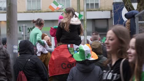 Celebración-En-Las-Calles-De-La-Ciudad-De-Corcho,-Gente-Con-Banderas-Y-Sombreros-De-Trébol,-St