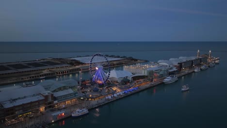 Vista-Aérea-De-Un-Barco-Pasando-La-Rueda-Centenaria-En-El-Navy-Pier,-Tarde-De-Mal-Humor-En-Chicago,-EE.UU.