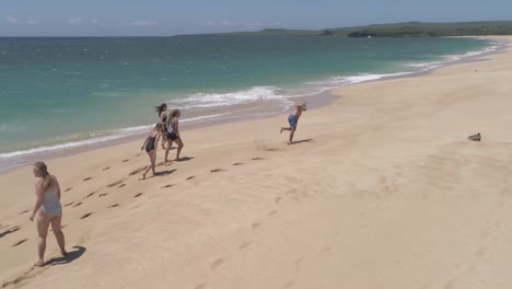 Chicos-Y-Chicas-En-Bikinis-Y-Trajes-De-Baño-Corriendo-Por-La-Playa-De-Papohaku-Maui-Hawaii-Tropezando-Y-Cayendo-En-La-Arena