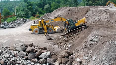 Bagger-Und-Lader-Durch-Sandhaufen-In-Der-Verarbeitungsstätte-Der-Merapi-Mine-In-Indonesien