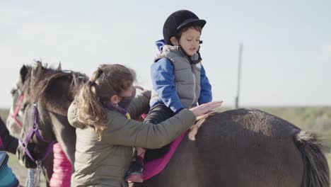 El-Niño-Le-Da-Un-Abrazo-Cariñoso-Al-Caballo-Con-La-Ayuda-Del-Entrenador-De-Animales