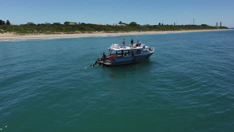 Luftumlaufbahnen,-Scubabo-Charterboot-Mit-Tauchern-Am-Sandstrand