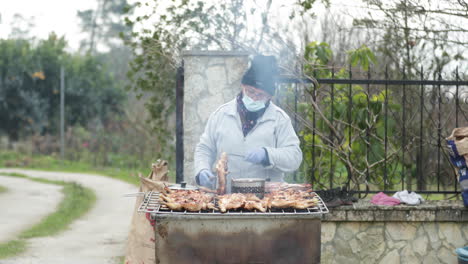 Mujer-Aldeana-Con-Mascarilla-Vendiendo-Pollo-A-La-Parrilla-En-Una-Calle-Lateral-En-Leiria,-Portugal