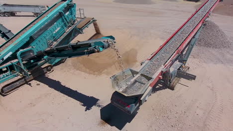 Cinematic-drone-shot-rotating-around-rocks-moving-up-a-conveyer-belt-in-a-rock-quarry