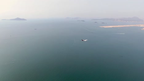 Commercial-airplane-approaching-Hong-Kong-International-airport,-passing-above-Hong-Kong-Zhuhai-Macao-Bridge,-the-longest-Sea-crossing-in-the-world