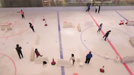 In-Einem-Einkaufszentrum-In-Hong-Kong-Sieht-Man-Menschen-Jeden-Alters,-Wie-Sie-Das-Indoor-eislaufen-Genießen-Und-Lernen