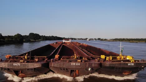 Low-Aerial-View-Tracking-Forward-Bow-Of-Veerhaven-Pusher-Boat-Transporting-Three-Barges-Along-Oude-Mass