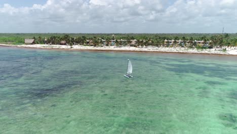 4K-Filmdrohnenaufnahme,-Die-Einen-Bogen-Um-Ein-Segelboot-Macht,-Das-Auf-Dem-Türkisfarbenen-Wasser-Der-Karibik-In-Tulum,-Mexiko,-Fährt