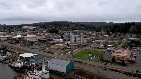 Drone-Volando-Hacia-El-Edificio-De-Apartamentos-Tioga-En-El-área-Del-Muelle-De-Coos-Bay-En-Oregon-Con-La-Autopista-De-La-Costa-De-Oregon-En-Primer-Plano