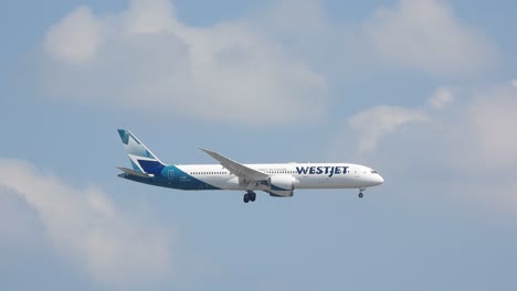 Transatlántico-De-Westjet-Descendiendo-Y-Preparándose-Para-Aterrizar-En-El-Aeropuerto,-Cielo-Azul-Nublado