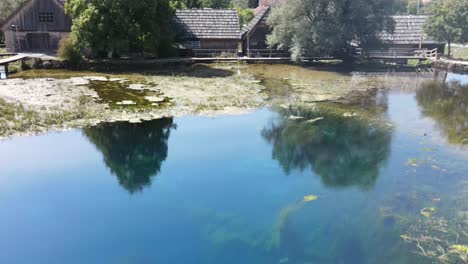 Majerovo-Vrilo,-Eine-Quelle-Des-Flusses-Gacka,-Mit-Holzmühlen-Im-Hintergrund