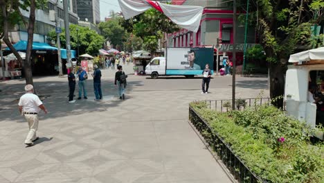 Aerial-dolly-in-low-angle-of-public-square-with-drama-series-marketing-truck