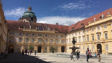 Pralatenhof-Innenhof-Im-Steifen-Schloss-Melk-Auf-Der-Spitze-Eines-Hügels-über-Der-Stadt-Melk-Mit-Herumlaufenden-Touristen