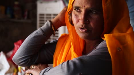 Portrait-of-authentic-middle-aged-Indian-woman-with-yellow-orange-sari-talking-and-smiling,-Rajasthan