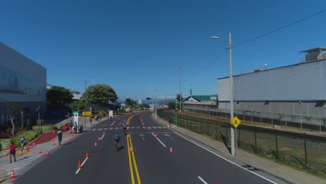 Toma-De-Drones-De-Carrera-Ciclista-Sobre-Asfalto-En-La-Ciudad,-Competencia-De-Triatlón