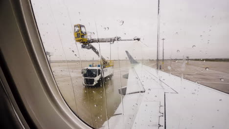 Enteisungslaster-Besprüht-Flugzeugflügel,-Vom-Fenster-Des-Beifahrersitzes-Aus-Gesehen