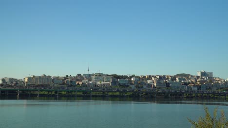 Han-River-Park-Waterfront-with-Hannam-dong,-Yongsan-gu-and-N-Seoul-Tower-on-blue-sky---copy-space-template