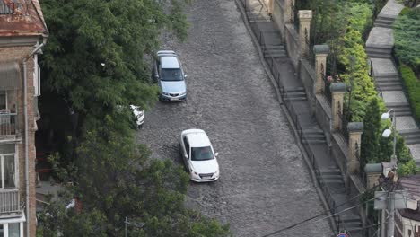 Auf-Der-Straße-Fahrende-Fahrzeuge-Und-Ein-Mann-Auf-Dem-Fußgängerweg-In-Kiew,-Ukraine