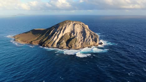 Drone-Inclinándose-Desde-El-Océano-Hasta-Una-Pequeña-Isla-Deshabitada-En-Hawaii