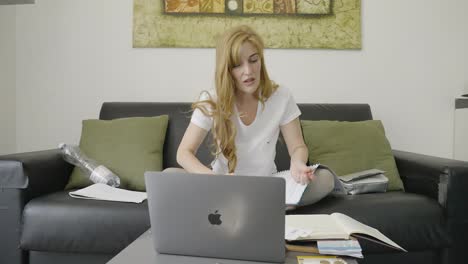 Businesswoman-drinking-coffee-at-home-while-working-on-her-laptop