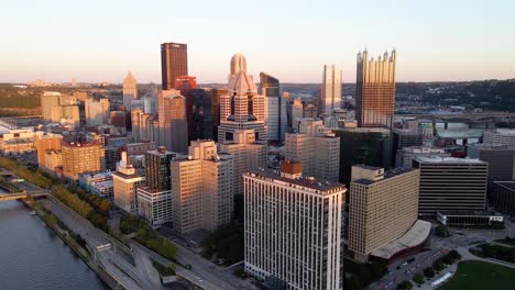 Aerial-view-of-sunlit-Pittsburgh-skyline,-sundown-in-northeast-USA---descending,-drone-shot