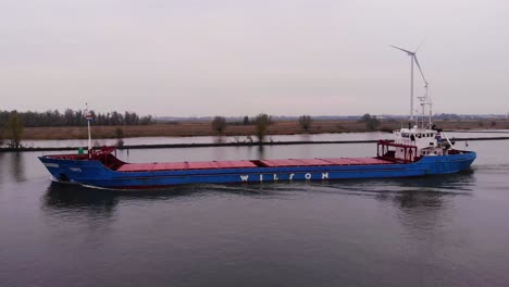 Aerial-Tracking-Shot-Along-Port-Side-of-Torpo-Cargo-Ship-Along-Oude-Maas-During-Overcast-Day