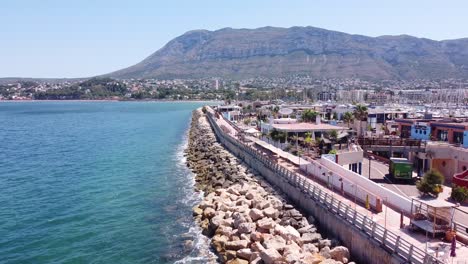 Denia-at-Costa-Blanca,-Spain---Aerial-Drone-View-of-the-Boulevard,-Restaurants,-Rock,-Port-and-Yacht-Boats