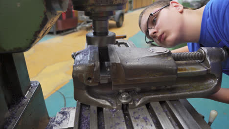 Joven-Estudiante-Practicando-Intensamente-Cómo-Usar-Un-Torno-De-Metal-En-Un-Taller-De-Escuela-Secundaria-Vocacional