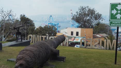 Pan-A-La-Derecha-De-Un-Viejo-Cañón-En-Campo-Verde-Del-Museo-Marítimo-Nacional,-Vista-Desde-Cerro-Artillería,-Valparaíso,-Chile