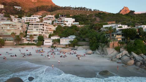 Gente-Relajándose-En-Una-Tercera-Playa-De-Clifton-En-Ciudad-Del-Cabo,-Sudáfrica-Durante-La-Puesta-De-Sol,-Antena