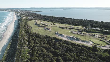 Dron-Sobrevolando-El-Campo-De-Golf-Magenta-Shores-Entre-La-Playa-Magenta-Y-El-Lago-Tuggerah