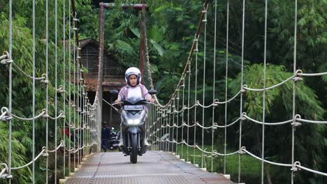 Puente-Colgante-Sobre-El-Río-Con-Cruce-De-Motocicletas-Por-La-Mañana-En-Sukabumi,-Java-Occidental,-Indonesia-El-4-De-Mayo-De-2022