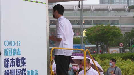 Residents-queue-in-line-to-receive-PCR-tests-for-coronavirus-from-a-Community-Testing-Centre-truck-to-tackle-the-spread-of-the-virus-and-a-pandemic-wave-near-Hong-Kong's-financial-district