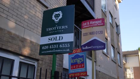 Canary-Wharf-London-United-Kingdom-July-2022-three-estate-agent-boards-sit-alongside-a-block-of-flats