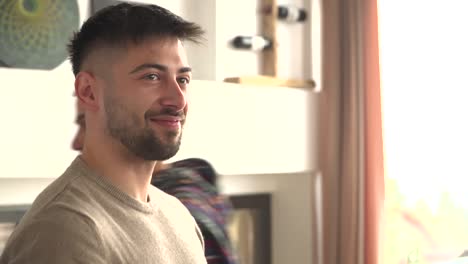 Man-with-short-dark-hair-and-scruffy-beard-smiles-while-attending-group-yoga-retreat