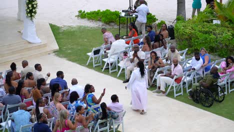 Pastora-Oficiante-Camina-Por-El-Pasillo-En-Una-Boda-Al-Aire-Libre-En-Un-Resort-Tropical