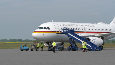 Equipo-De-Apoyo-Cerca-Del-Avión-Aterrizado,-Escaleras-Acercándose-A-La-Puerta