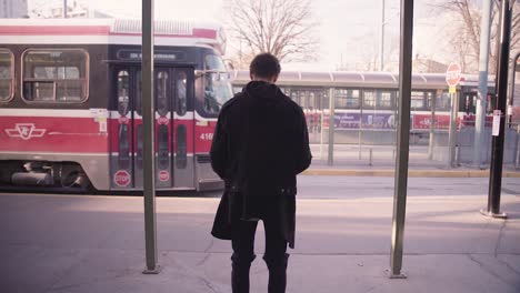 Streetcar-Arrives-in-Station-in-Front-of-Trendy-Young-Mixed-Race-Man