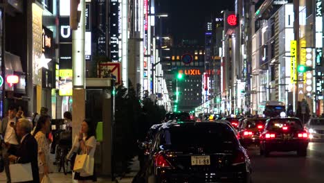 Der-Blick-Auf-Die-Berühmte-Einkaufsstraße-Ginza,-Autos-Und-Gehende-Menschen-In-Der-Nacht