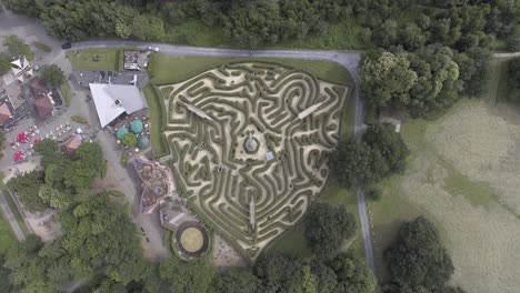 A-top-down-drone-shot-from-a-big-maze-in-the-Netherlands,-with-people-walking-inside-the-maze